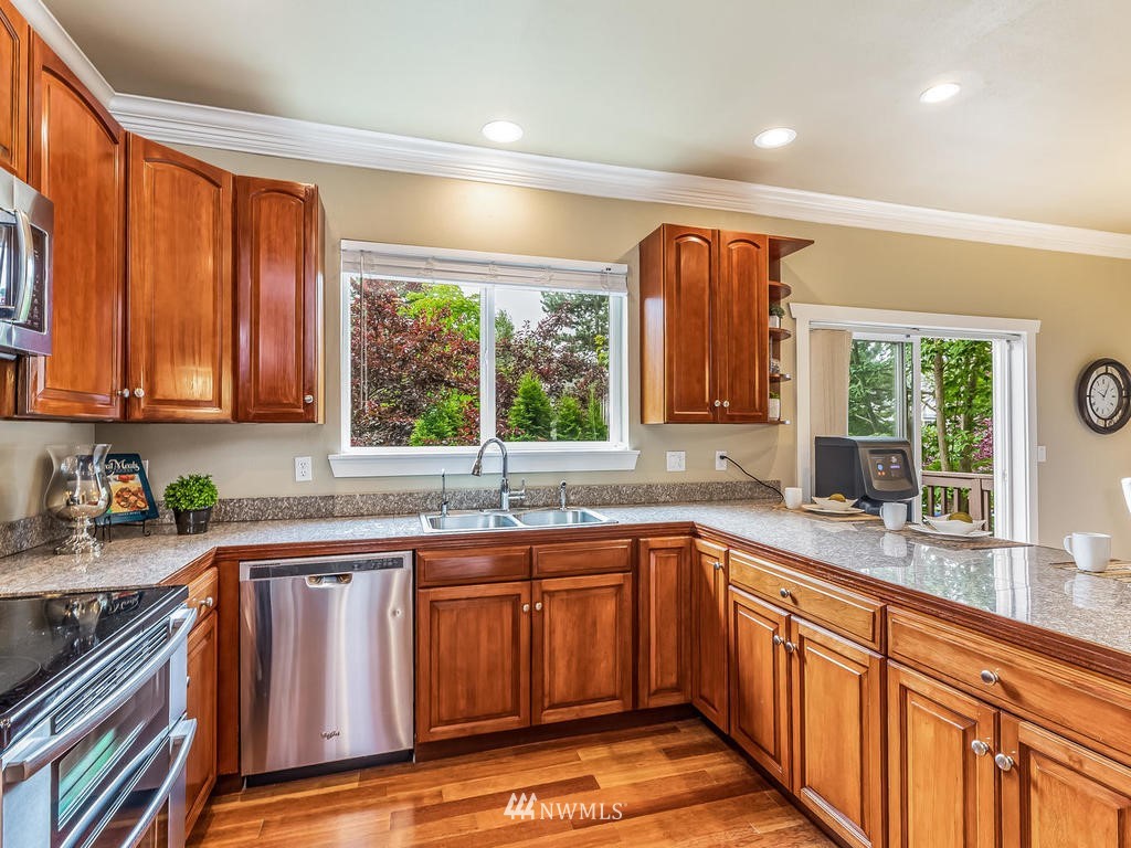 2019 Northeast 9th Court, Unit A Renton, WA 98056 - Photo 10 of 26 a kitchen with stainless steel appliances granite countertop a sink and wooden cabinets