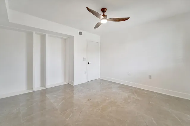 an empty room with a empty space and a ceiling fan