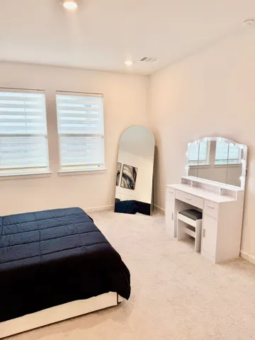 a living room with a bed and a dresser