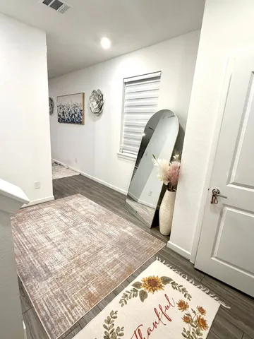 a view of a hallway to room with wooden floor and staircase