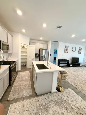a large white kitchen with a stove a sink a microwave and a refrigerator