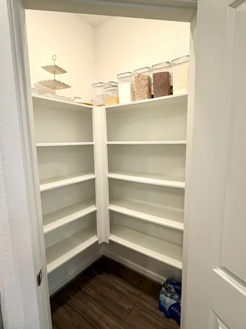 a view of walk in closet with empty racks