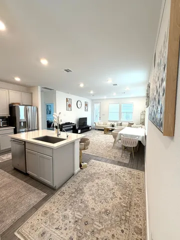 a living room with a couch and a view of kitchen