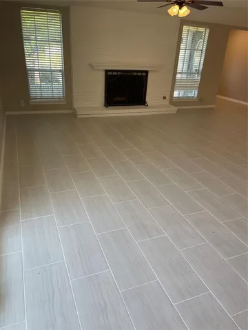 an empty room with windows and fireplace