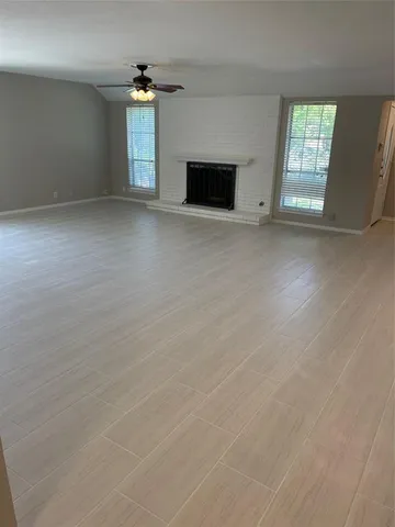 an empty room with windows and ceiling fan
