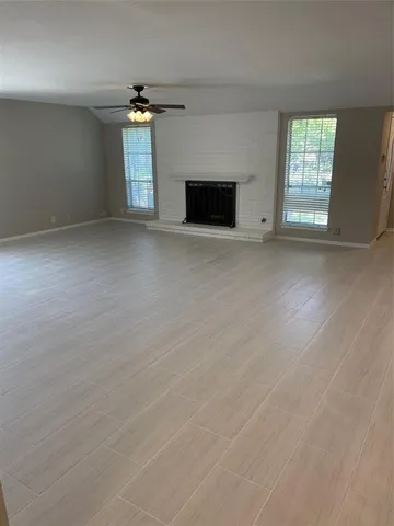 an empty room with windows and fireplace