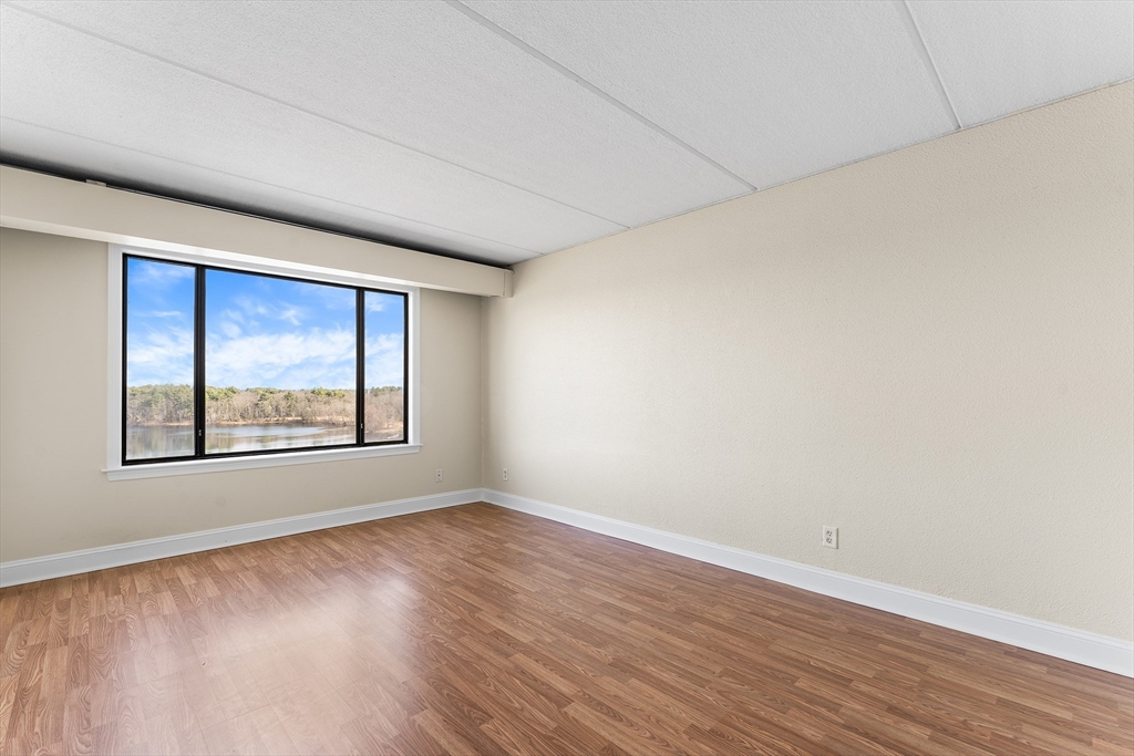 1500 Worcester Road, Unit 830 Framingham, MA 01702 - Photo 11 of 23 a view of an empty room with wooden floor and a window