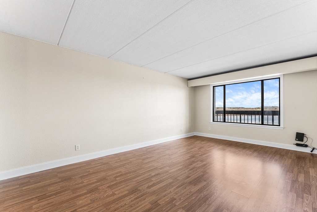 1500 Worcester Road, Unit 830 Framingham, MA 01702 - Photo 14 of 23 a view of an empty room with wooden floor and a window