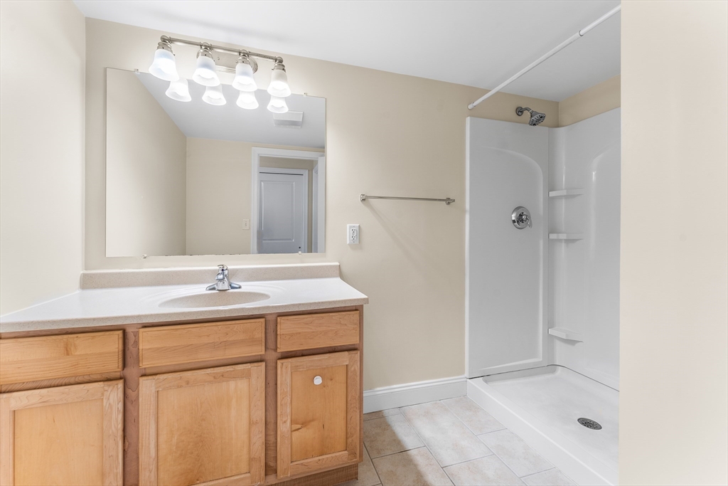 1500 Worcester Road, Unit 830 Framingham, MA 01702 - Photo 18 of 23 a bathroom with a granite countertop sink a mirror and shower