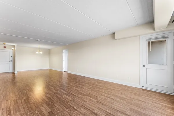 a view of empty room with wooden floor and entryway