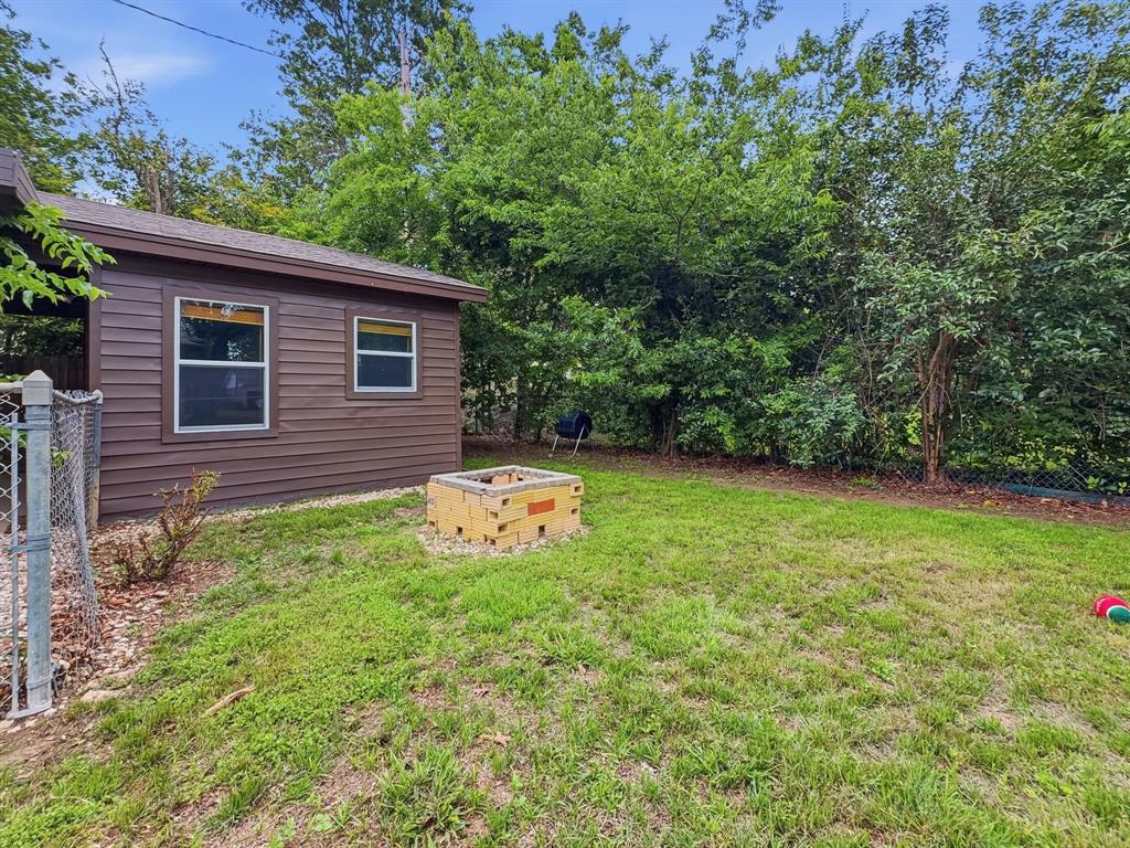 2137 Lenamon Street Waco, TX 76710 - Photo 25 of 29 Expansive grassy area featuring a built-in fire pit with brick construction