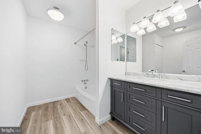 a bathroom with a sink vanity granite and a mirror