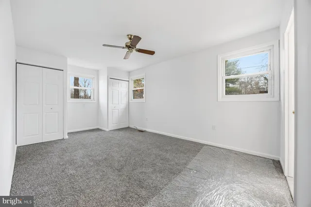 a view of room with ceiling fan and window