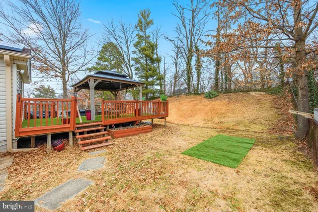 a view of a house with a swimming pool and wooden fence