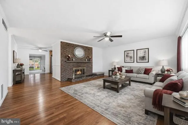 a living room with fireplace furniture and a wooden floor