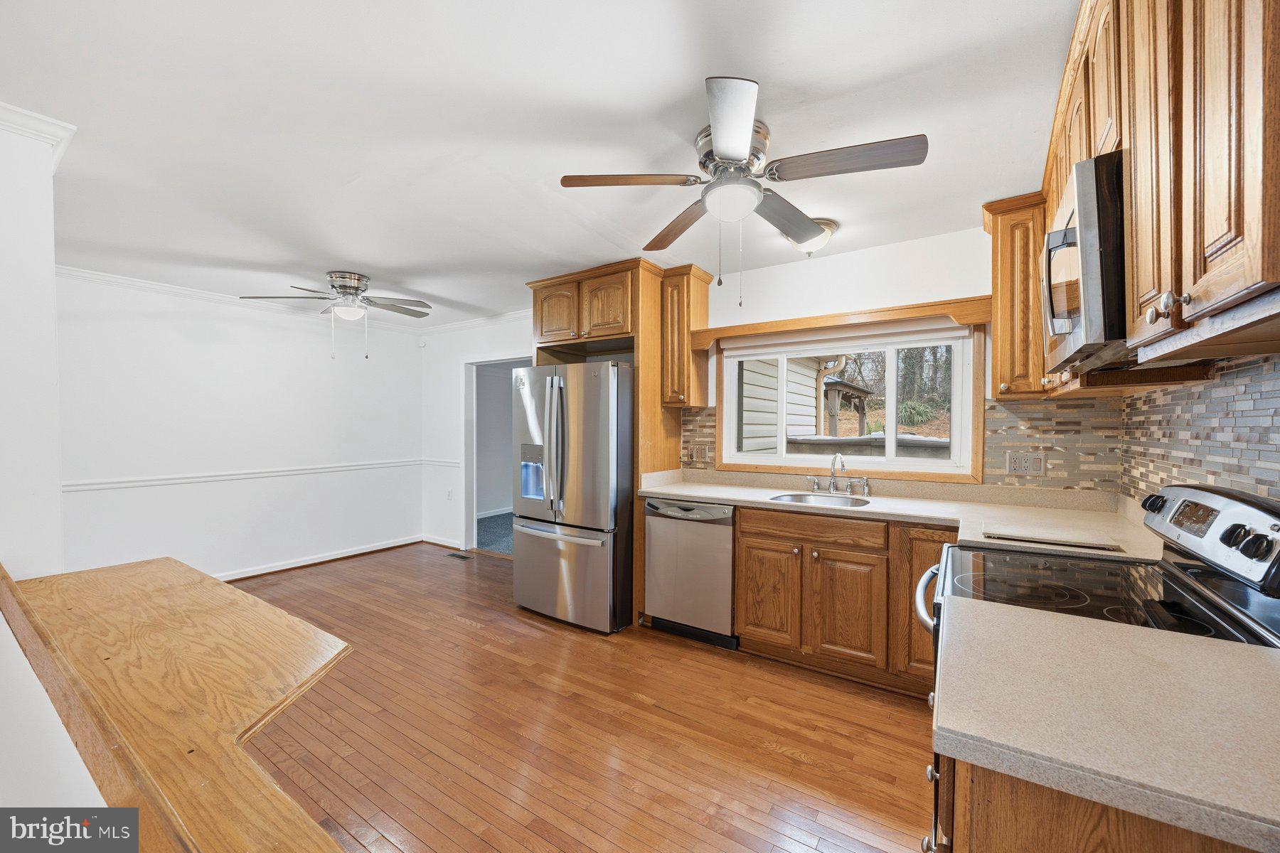 341 Dameron Street South Laurel, MD 20724 - Photo 10 of 32 a kitchen with stainless steel appliances granite countertop a refrigerator a sink dishwasher a stove and white countertops with wooden floor