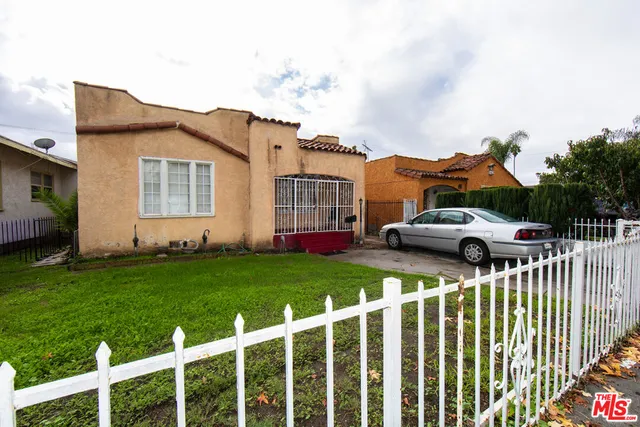 a front view of house with yard and car parked