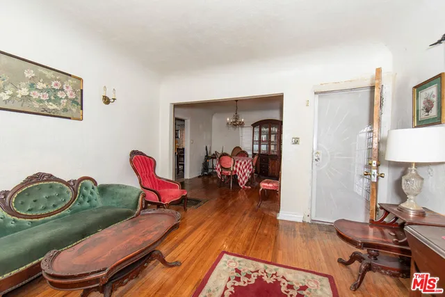 a living room with furniture a wooden floor and next to a window