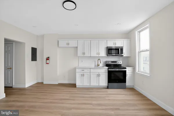 a kitchen with granite countertop a refrigerator stove top oven and sink