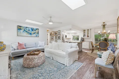 a living room with furniture potted plant and kitchen view