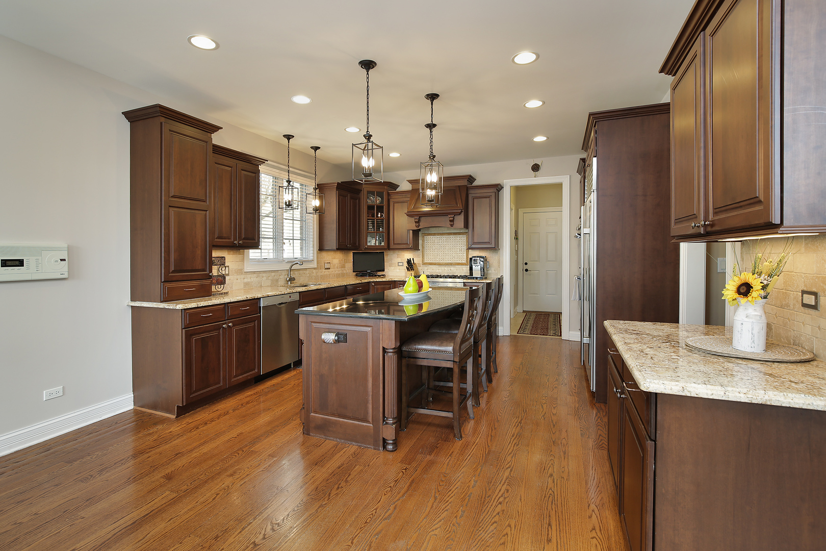 608 Revere Road Glenview, IL 60025 - Photo 8 of 34 a kitchen with stainless steel appliances kitchen island granite countertop a table chairs stove and refrigerator
