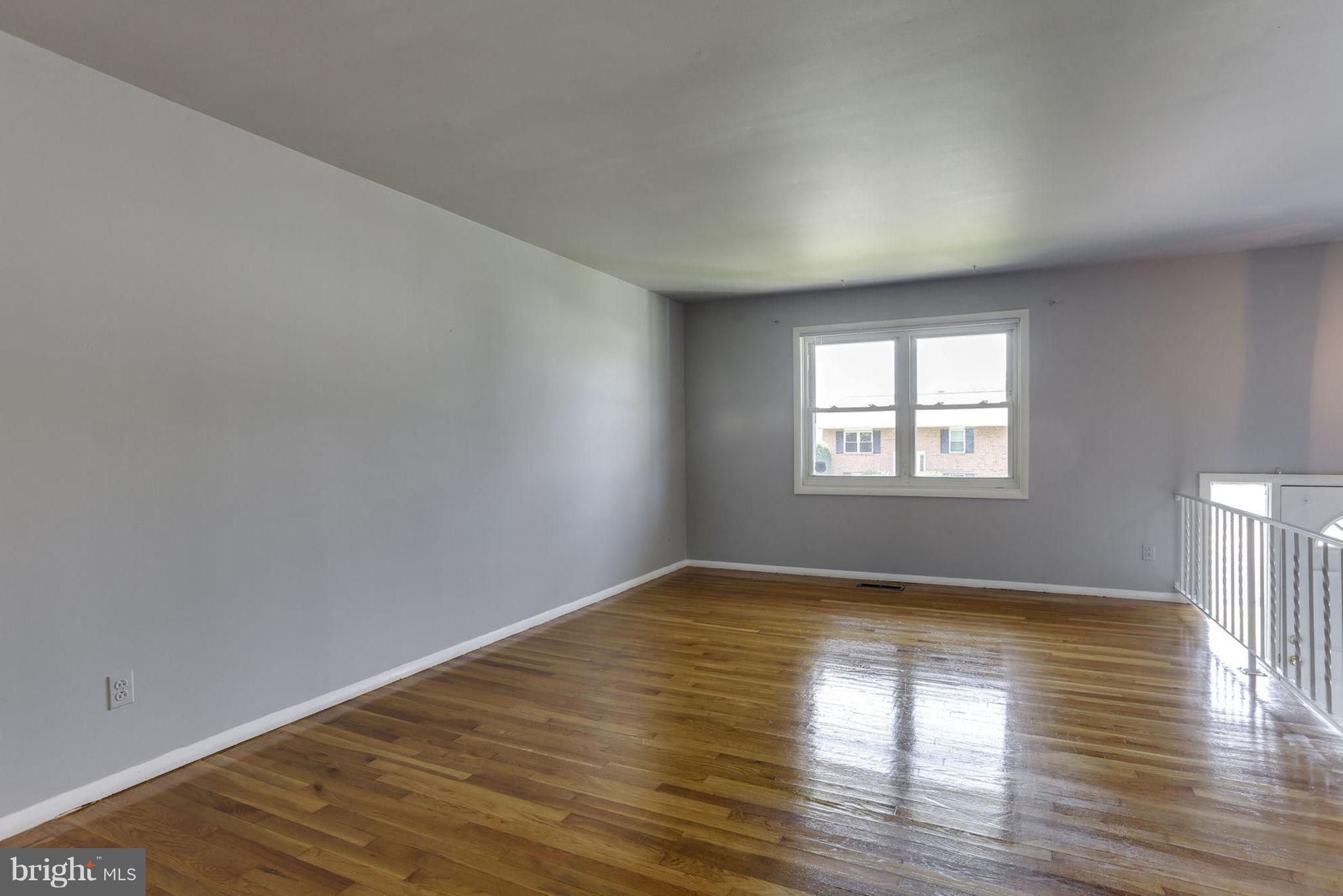 8806 Selina Road Randallstown, MD 21133 - Photo 5 of 30 a view of an empty room with window and wooden floor