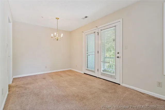 an empty room with chandelier fan