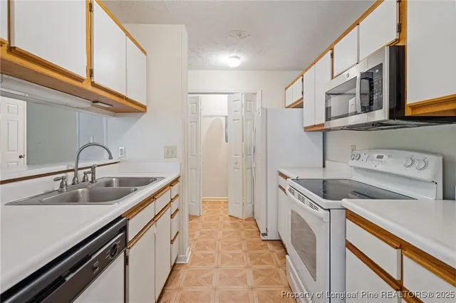 a kitchen with stainless steel appliances granite countertop a sink and a refrigerator