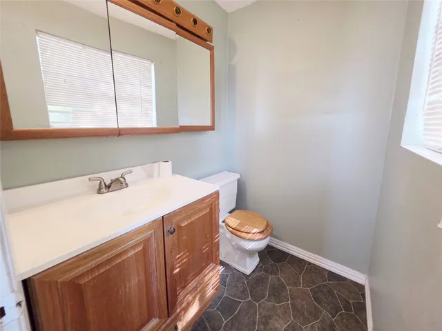 a bathroom with a sink a toilet and a mirror