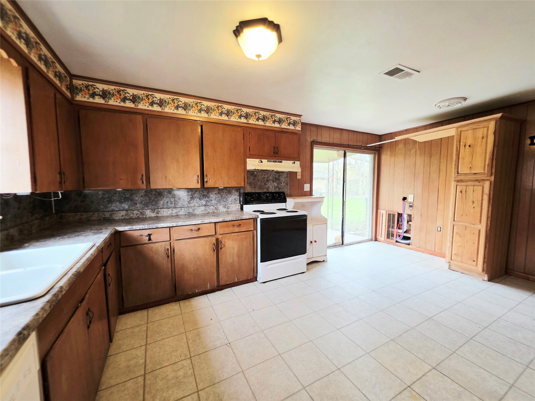111 South Harvey House Road Somerville, TX 77879 - Photo 9 of 22 a large kitchen with granite countertop a stove top oven a sink and dishwasher