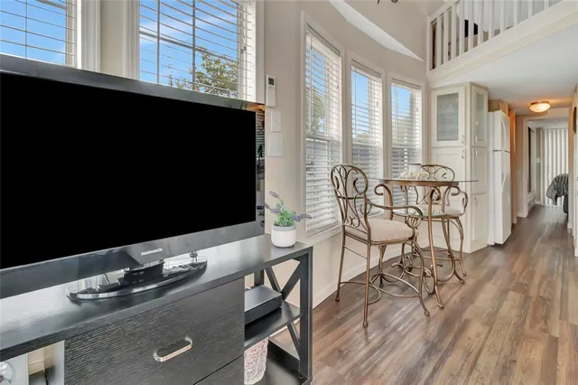a living room with furniture a flat screen tv and floor to ceiling window