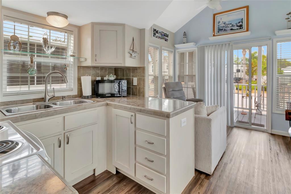 20285 Highway 27, Unit 38 Clermont, FL 34715 - Photo 9 of 33 a kitchen with white cabinets and wooden floors