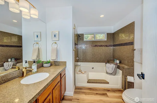 a bathroom with a granite countertop sink mirror vanity and toilet