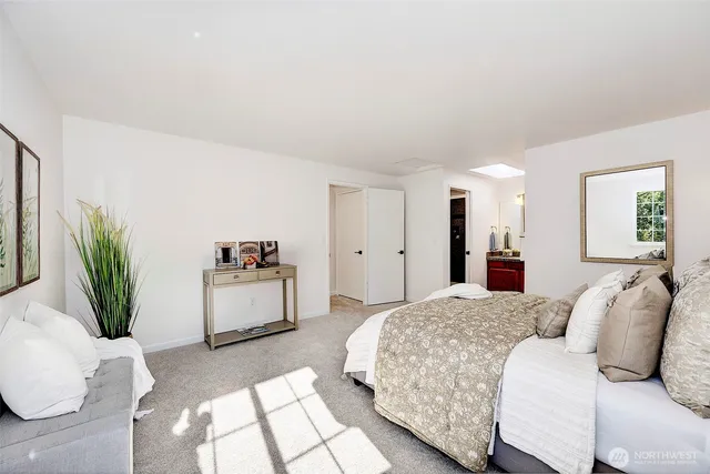 a bedroom with a large bed and a potted plant