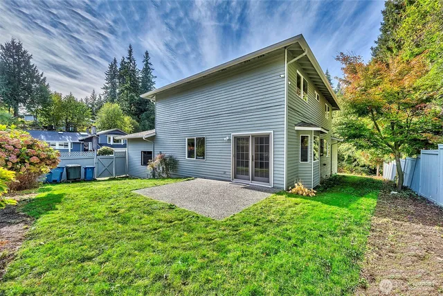 a view of a backyard with plants and large tree