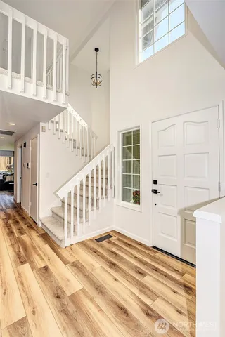 a view of a bedroom with wooden floor and windows
