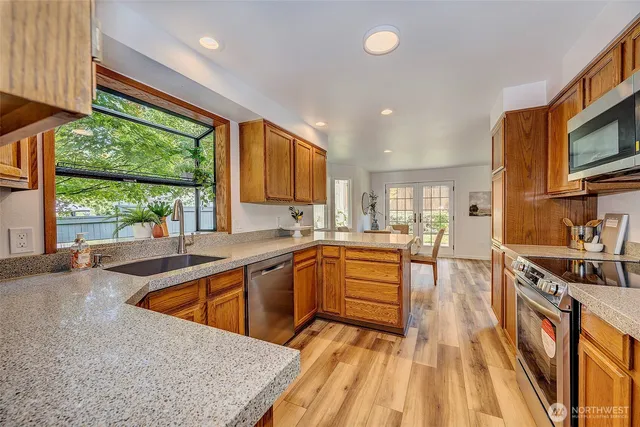 a kitchen with stainless steel appliances granite countertop a sink stove and cabinets