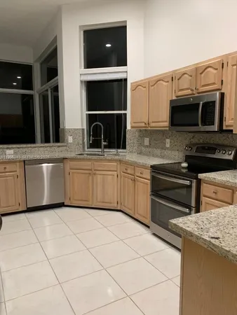 a kitchen with stainless steel appliances kitchen island granite countertop a sink and cabinets