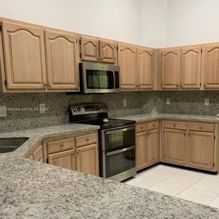 a kitchen with stainless steel appliances granite countertop a sink a stove a microwave and cabinets