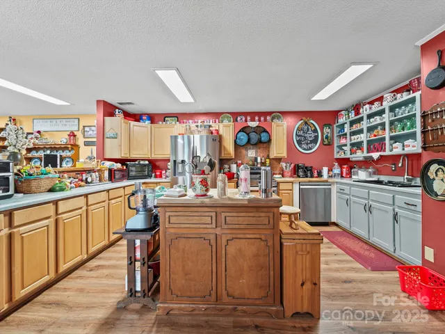 a kitchen with stainless steel appliances kitchen island granite countertop a stove and cabinets