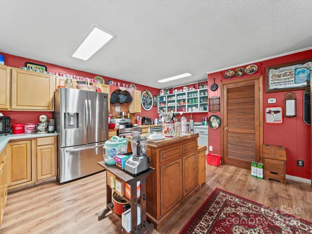 a kitchen that has a lot of cabinets and refrigerator in it