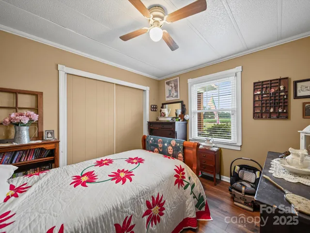 a bedroom with a bed and a dresser next to a window