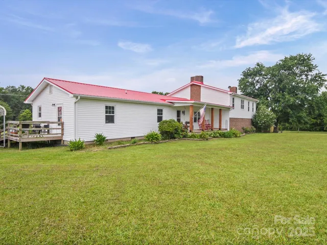 a front view of house with outdoor space and trees in the background