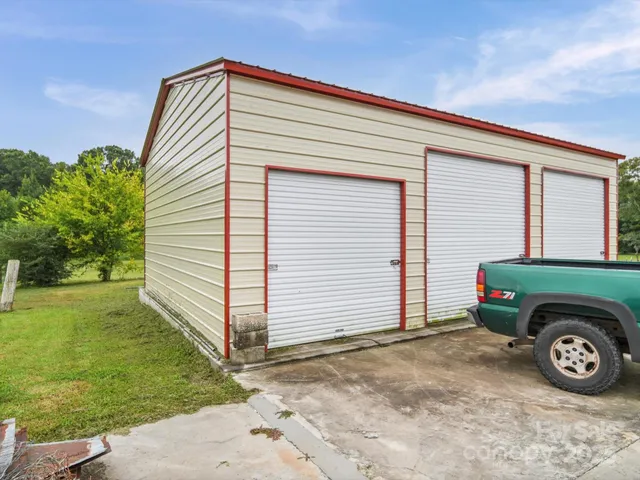 a view of garage and a car parked in a yard