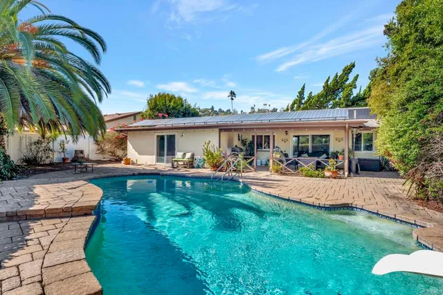 a view of a house with swimming pool and sitting area