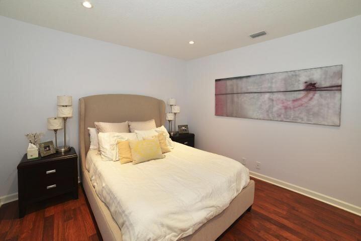 6167 Northwest 23rd Way Boca Raton, FL 33496 - Photo 21 of 28 a bedroom with a bed and wooden floor