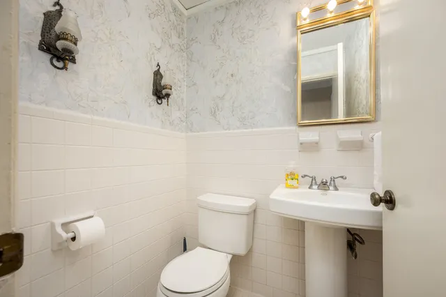 a bathroom with a sink a toilet and mirror