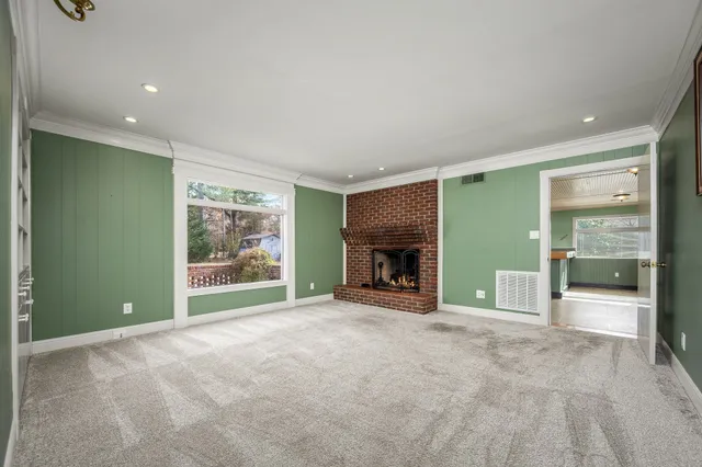 an empty room with floor to ceiling window and fireplace