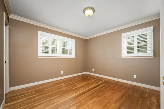 a view of a room with wooden floor and windows
