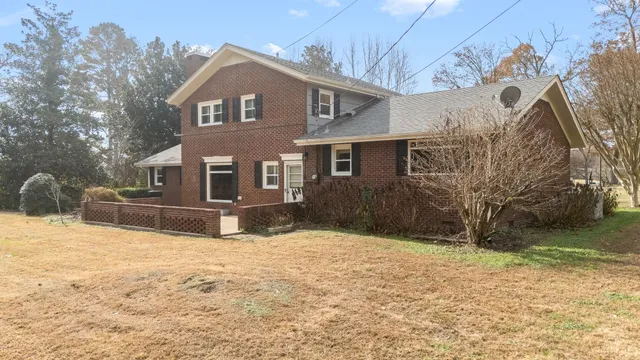 a front view of a house with a yard covered with snow